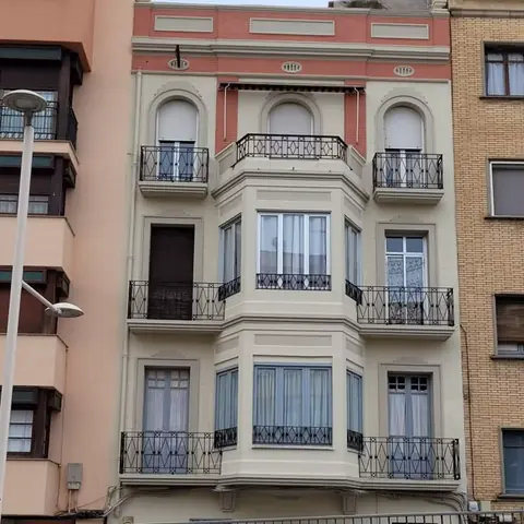 Después: fachada antigua con balcones de forja y miradores