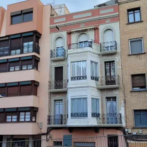 Después: fachada antigua con balcones de forja y miradores